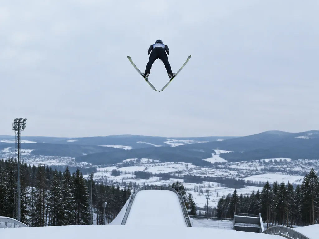 Backhoppare i luften med skidorna i V-stil
